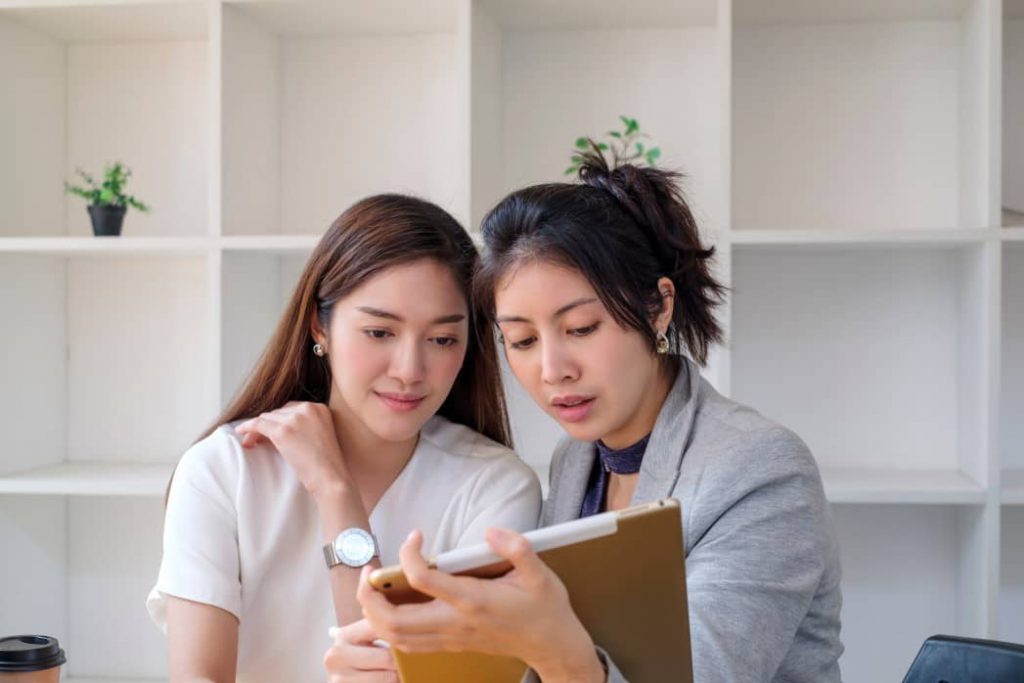 Two workers negotiating a confidential contract in a private room.