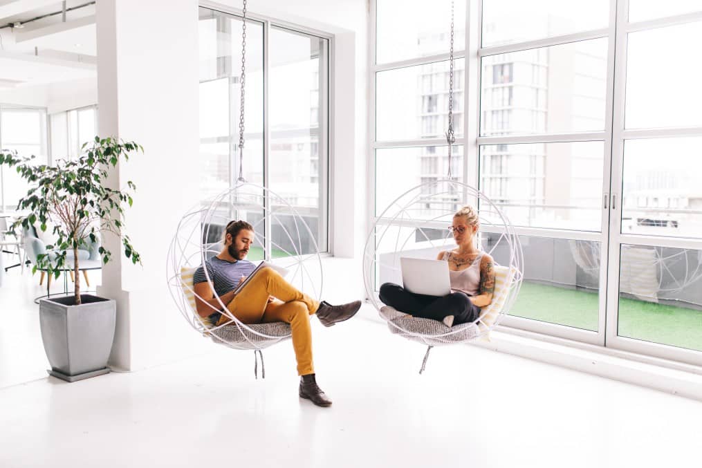 Two people working post covid in a shared office environment respecting social distancing.