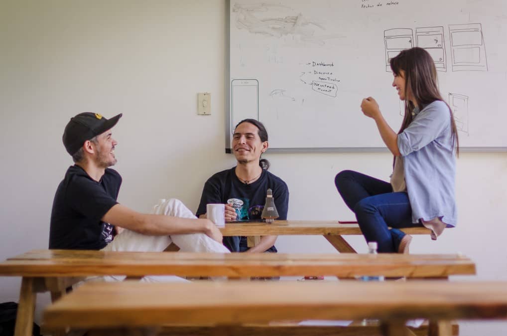 Three people working in a post covid environment where crowded team rooms are frowned upon.