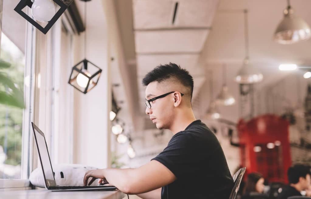 An asian man working with laptop in a creative and modern office