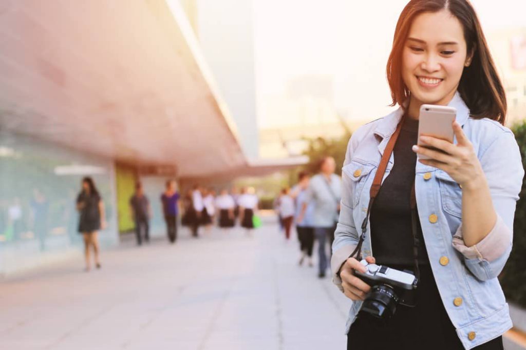 Young happy asian woman enjoying travel while using smartphone navigation and communicating at the street in the city travel, tourist, technology, communication, young woman, happy, navigator, asian woman, gps map, portrait, people, lifestyle, mobile phone, person, phone, smart phone, cellphone, cell phone, smartphone, mobile device