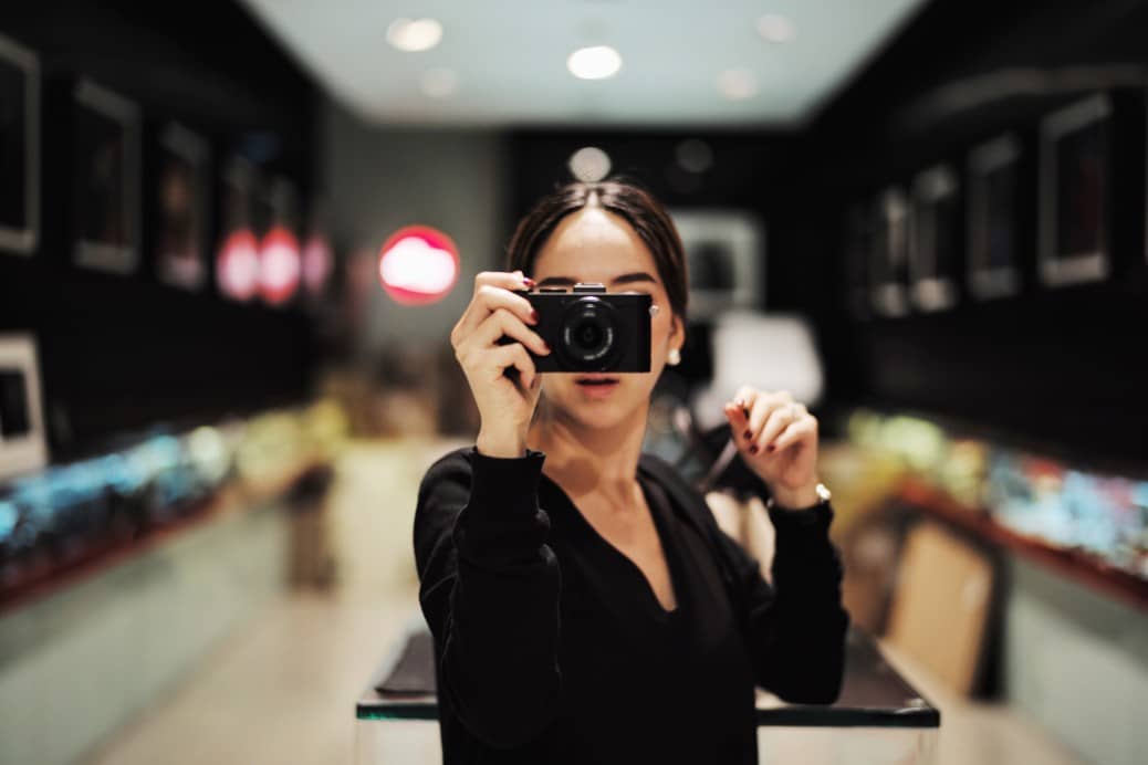 Independence coworking Singapore A woman taking a photo store, camera, young, woman, asian, picture, photo, test, takingphotos, leica, hand hold