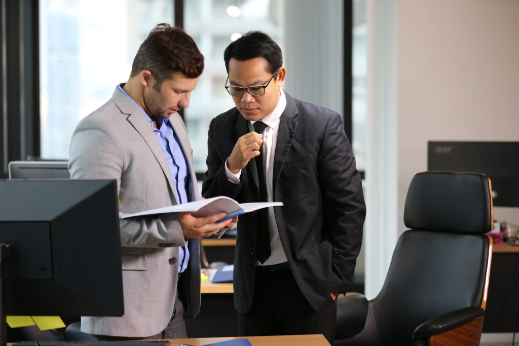 two businessmen looking at report in office coworking serviced office traditional office flexible