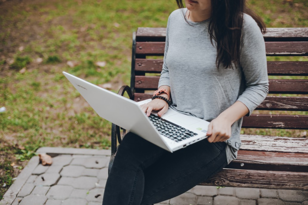 woman working at a park to cut down on office for rent cost